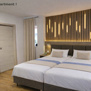 Modernes Hotelzimmer im Landhotel Römerkessel mit zwei zusammengestellten Einzelbetten, gepolstertem Kopfteil mit Holzdesign und indirekter Beleuchtung, Nachttischen und hellem Boden.